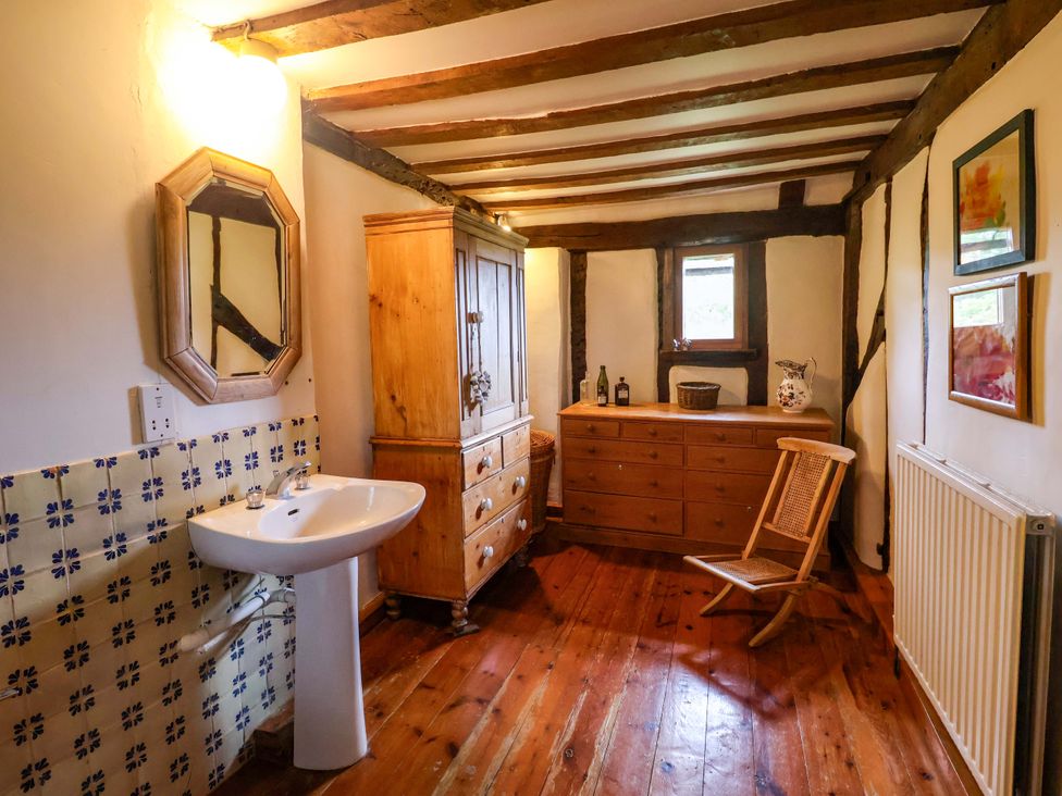 A bathroom with wooden furniture and a sink at Keirs Cottage in Carlton Colville