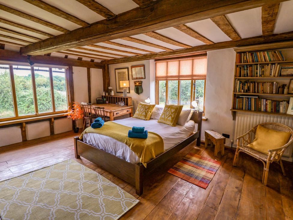 A bedroom with a bed and desk at Keirs Cottage Carlton Colville