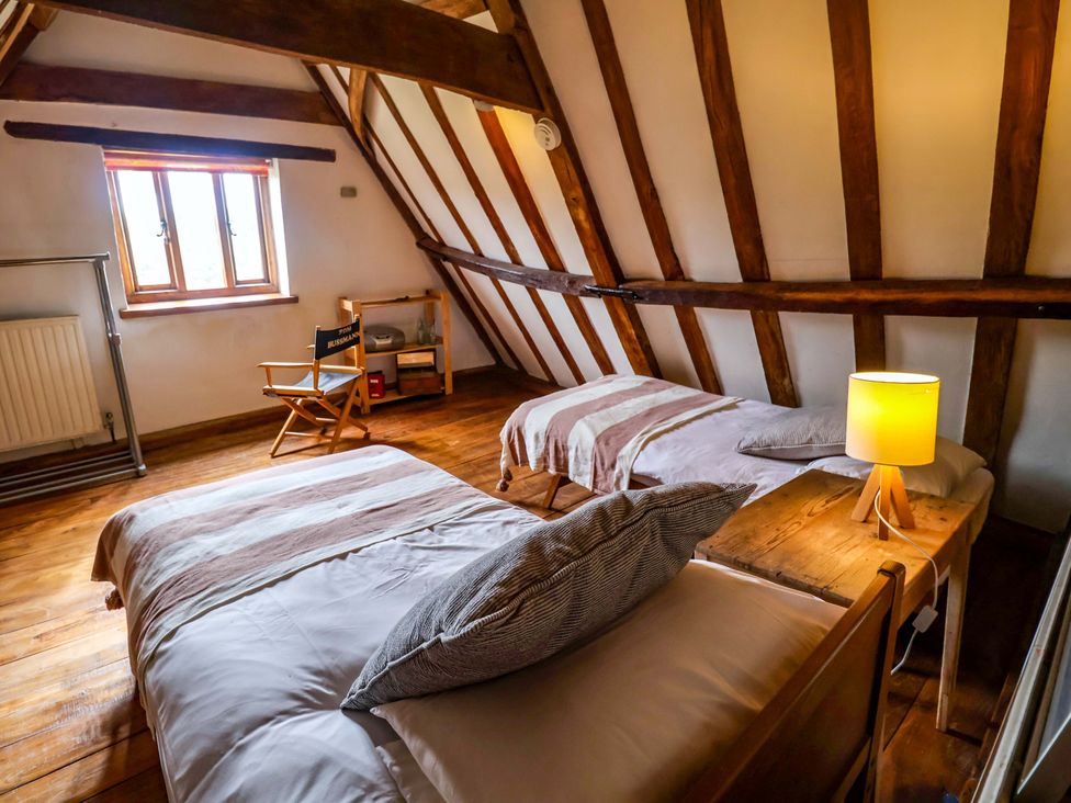A bedroom with two beds and a lamp at Keirs Cottage in Carlton Colville