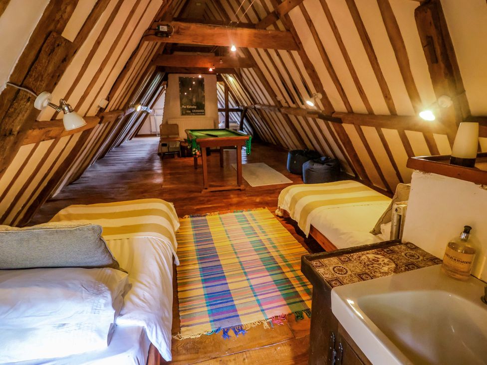 An attic with two beds and a pool table at Keirs Cottage in Carlton Colville