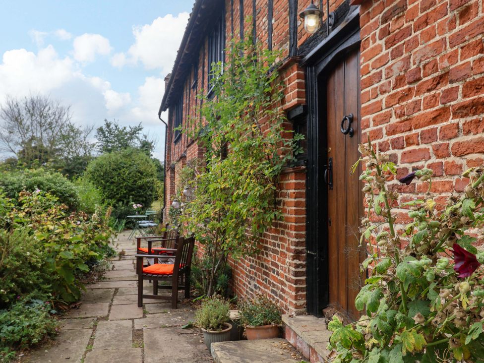 An outdoor area with a pathway and chairs at Keirs Cottage in Carlton Colville