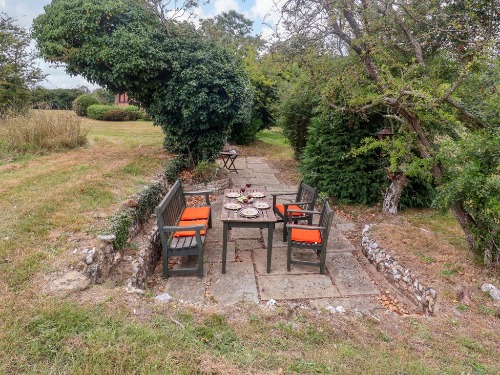 A garden with a table and chairs at Keirs Cottage in Carlton Colville