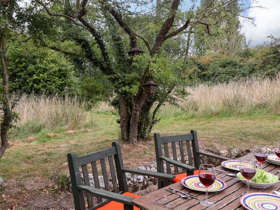 A garden table set with plates and glasses at Keirs Cottage in Carlton Colville