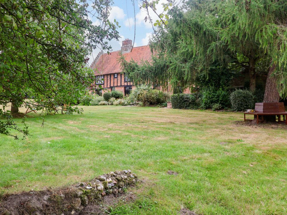 A garden with grass and trees at Keirs Cottage in Carlton Colville