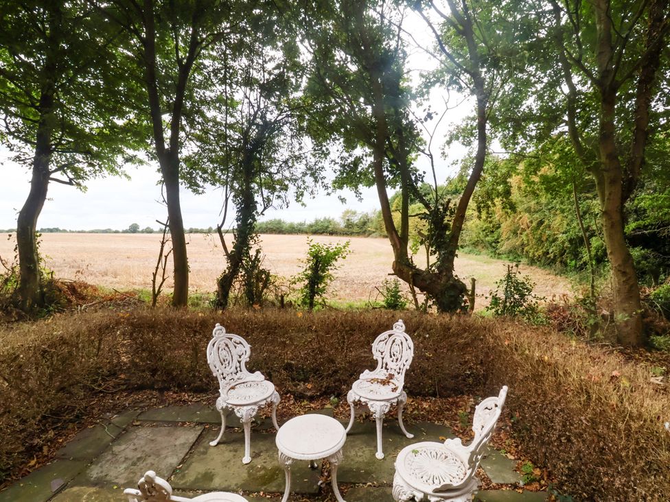 An outdoor seating area with chairs and a table at Keirs Cottage in Carlton Colville