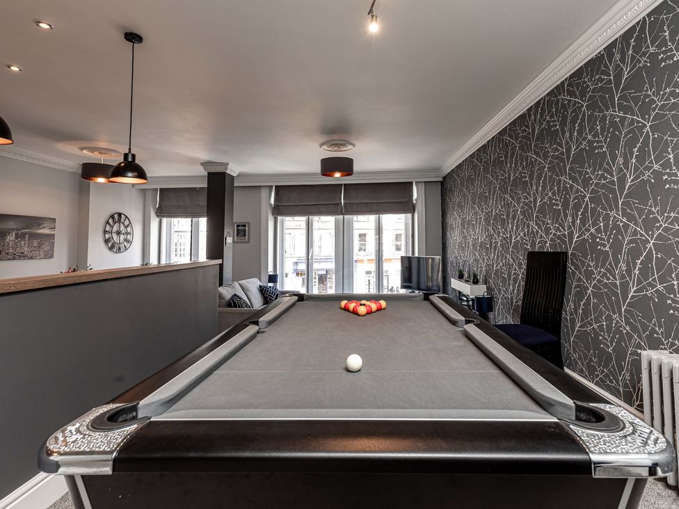 A game room with a pool table and sofa at The Crows Nest in Buxton