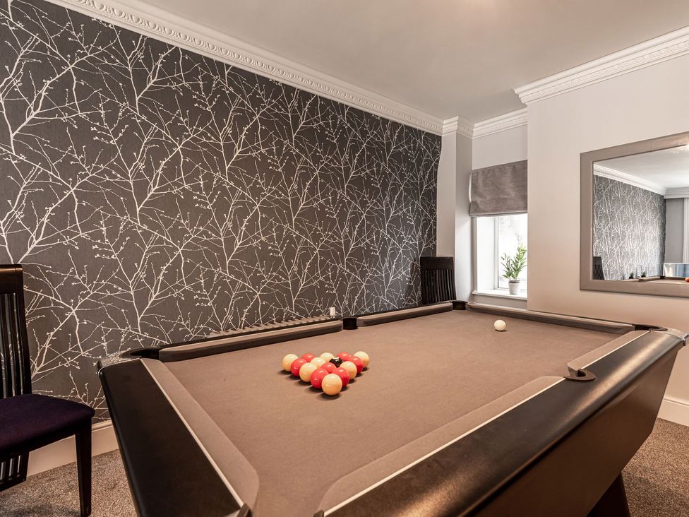 A game room with a pool table and chairs at The Crows Nest in Buxton