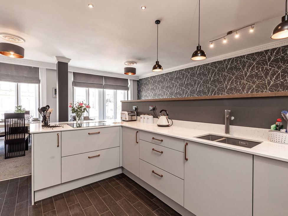 A kitchen with modern cabinets and appliances at The Crows Nest in Buxton