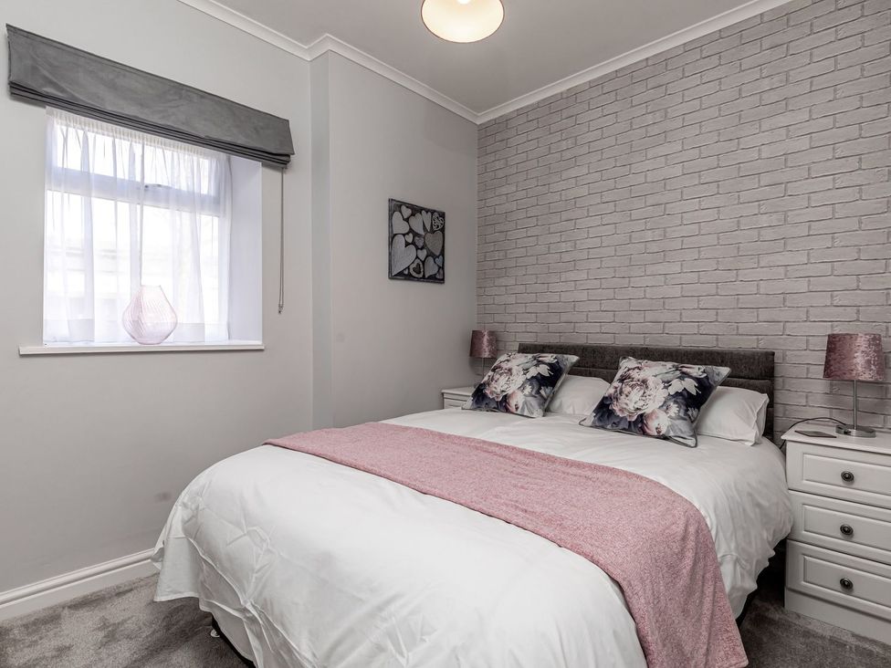 A bedroom with a bed and nightstands at The Crows Nest in Buxton