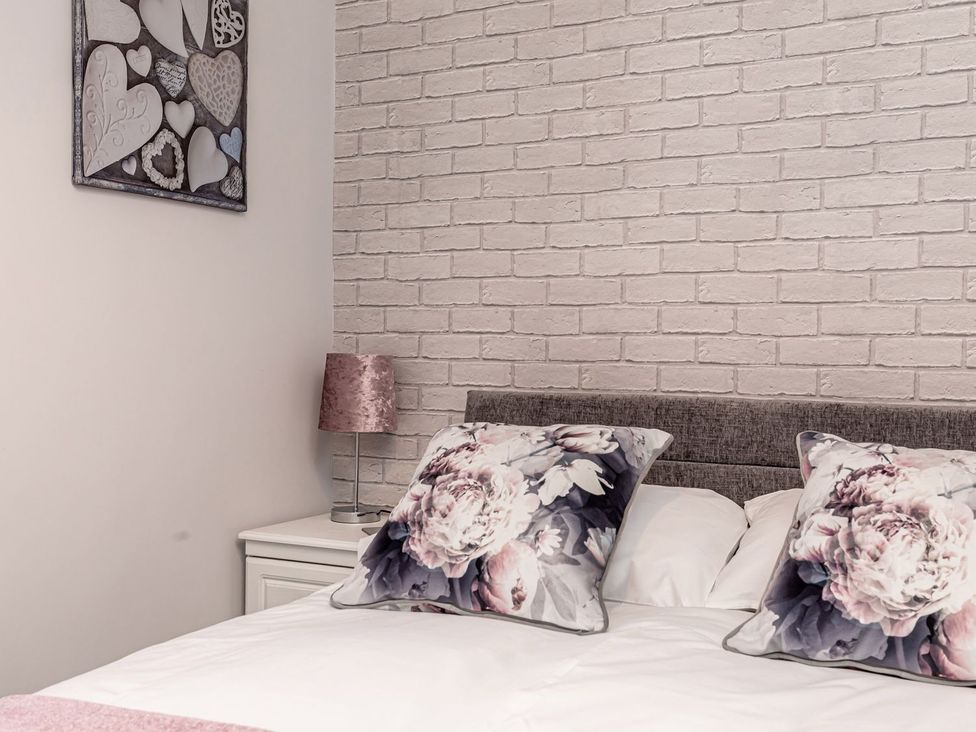 A bedroom with a bed and floral pillows at The Crows Nest in Buxton