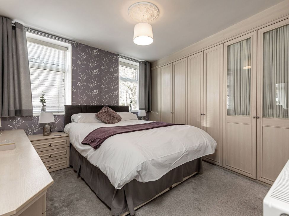 A bedroom with a bed and wardrobe at The Crows Nest in Buxton
