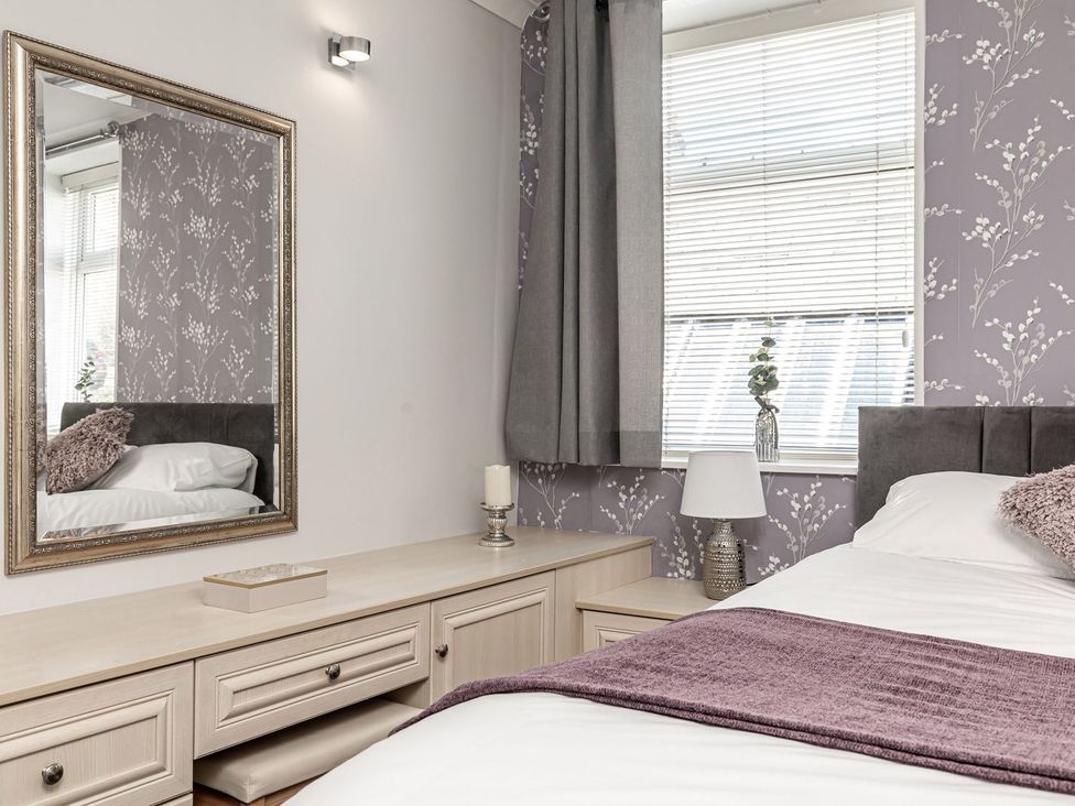 A bedroom with a bed and mirror at The Crows Nest in Buxton