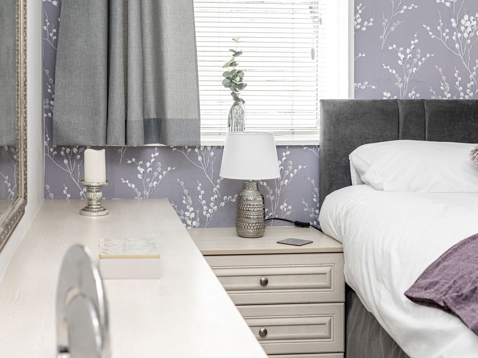 A bedroom with a bed and bedside table at The Crows Nest in Buxton