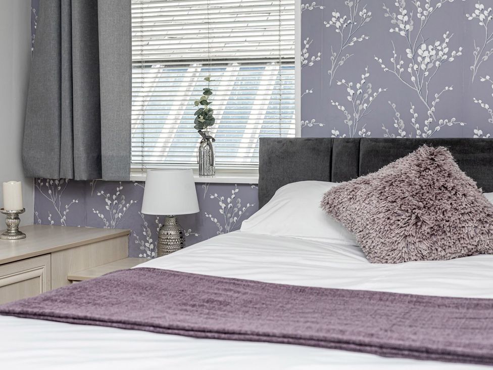 A bedroom with a bed and nightstand at The Crows Nest in Buxton