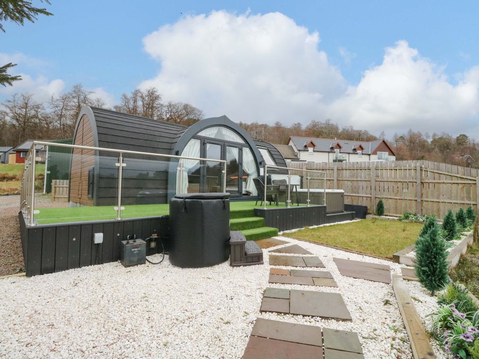 An outdoor area with a cabin and seating at Crofters Suite 