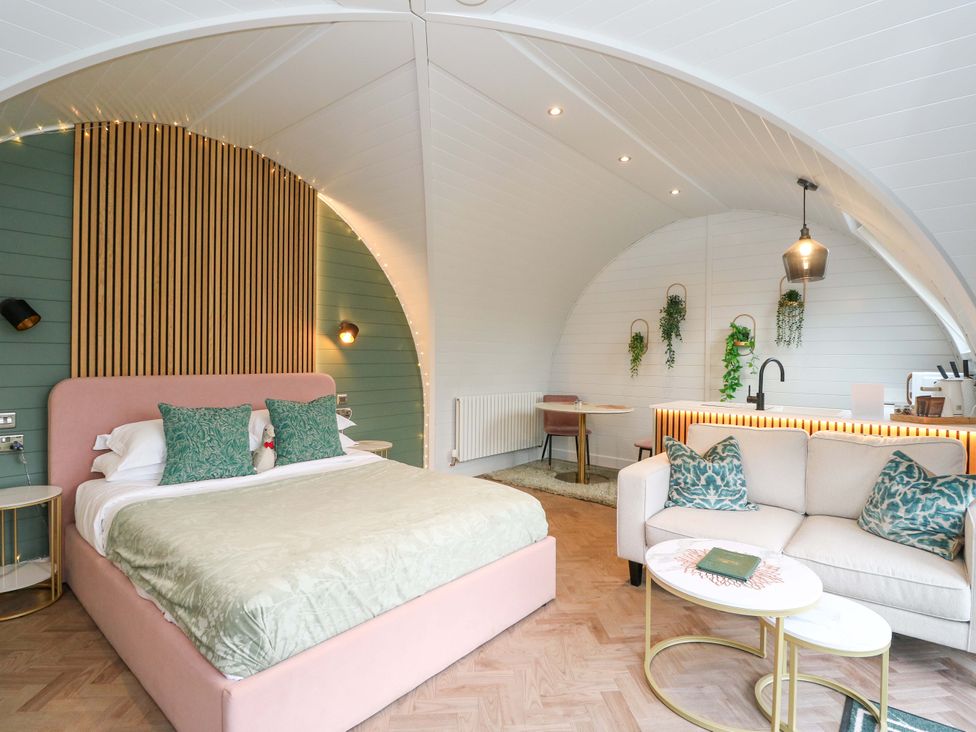 A bedroom with a bed and seating area at Crofters Suite