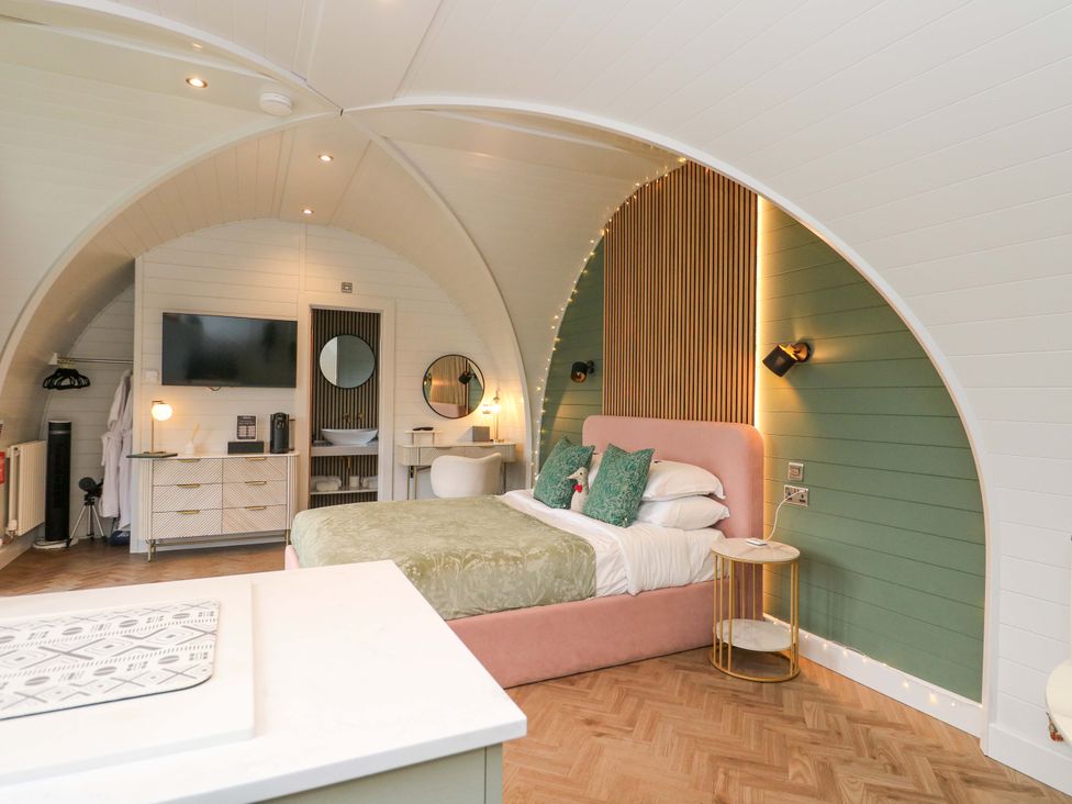 A bedroom with a bed and television at Crofters Suite