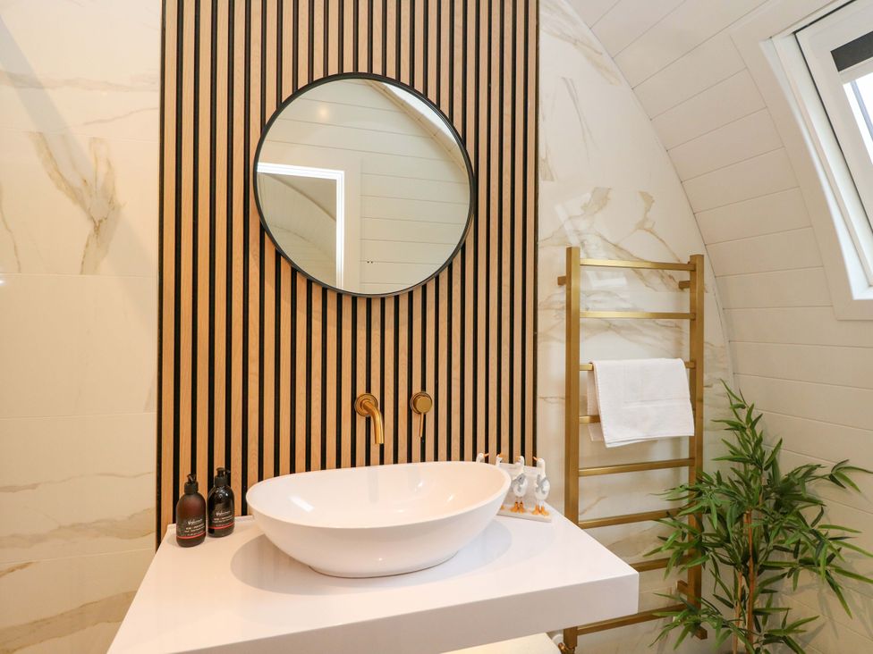 A bathroom with a sink and a mirror at Crofters Suite