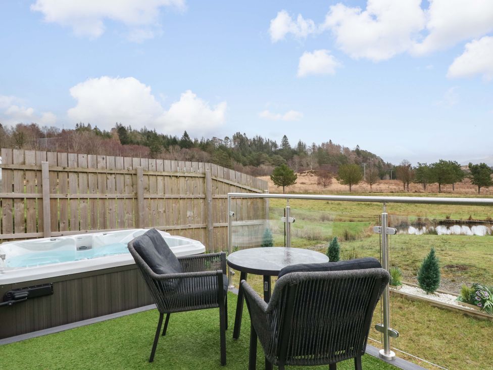 An outdoor space with a hot tub and seating area at Crofters Suite