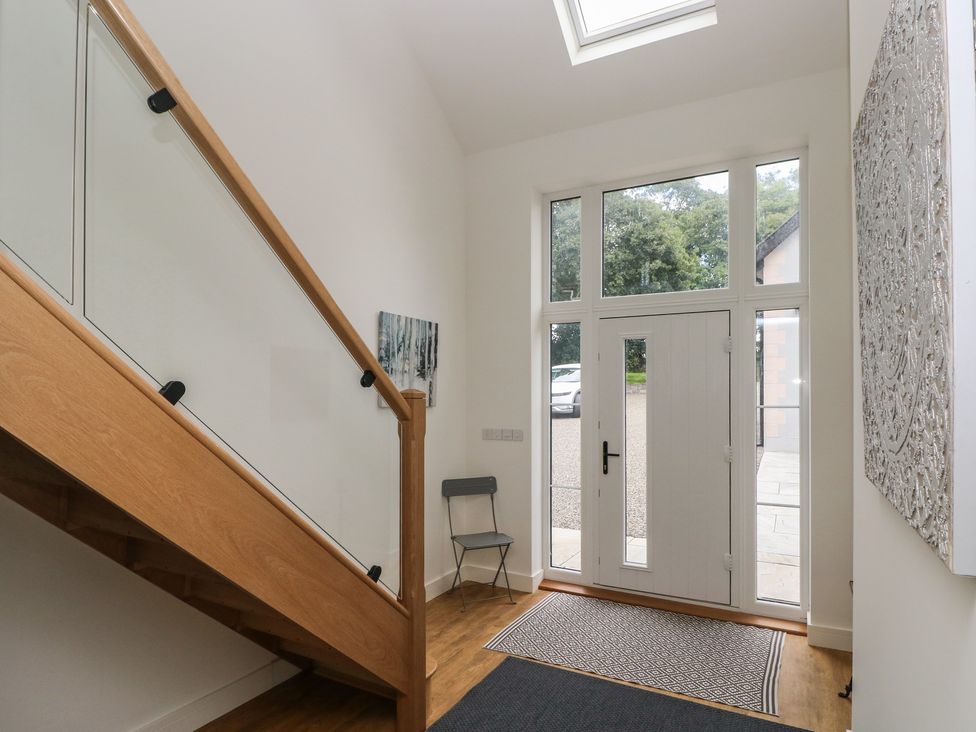 A hallway with a staircase and front door at Ty Landsker in Milford Haven