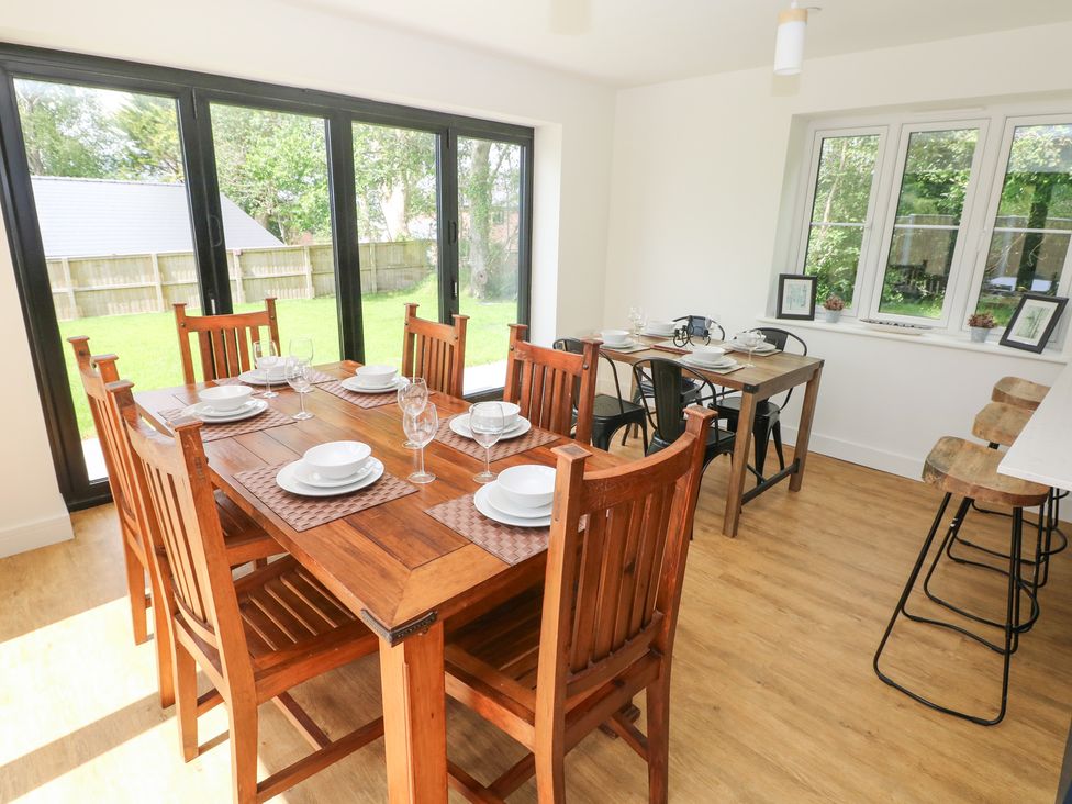 A dining room with a wooden table and chairs at Ty Landsker in Milford Haven
