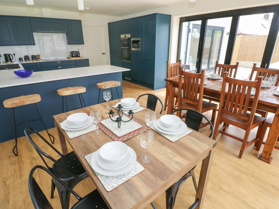 A kitchen with a dining area featuring a table and chairs at Ty Landsker in Milford Haven