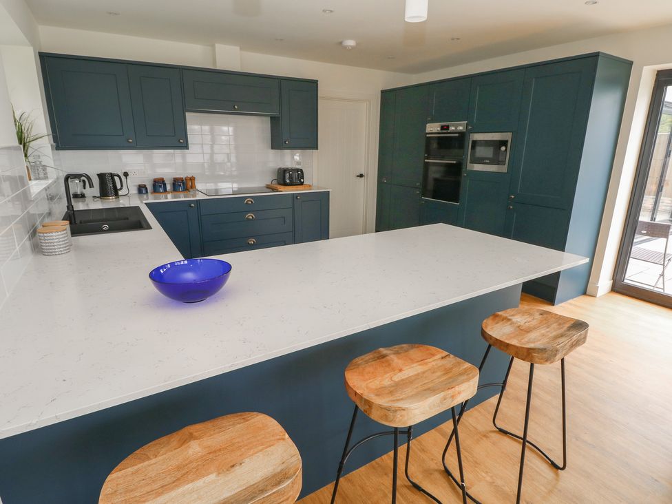 A kitchen with an island and appliances at Ty Landsker in Milford Haven