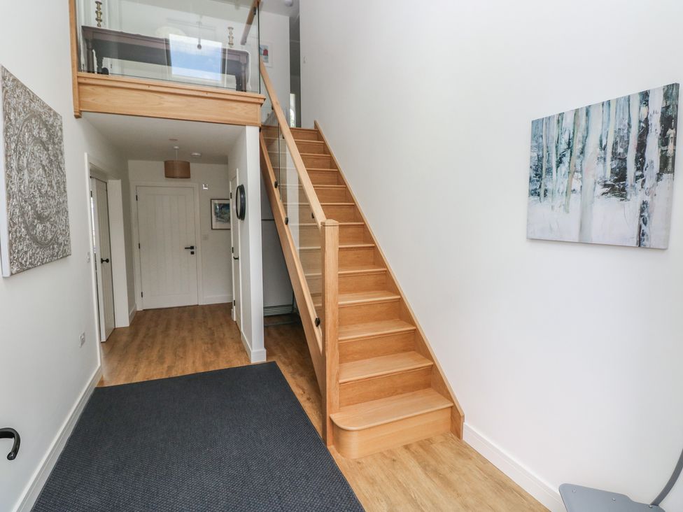 A hallway with stairs and artwork at Ty Landsker in Milford Haven