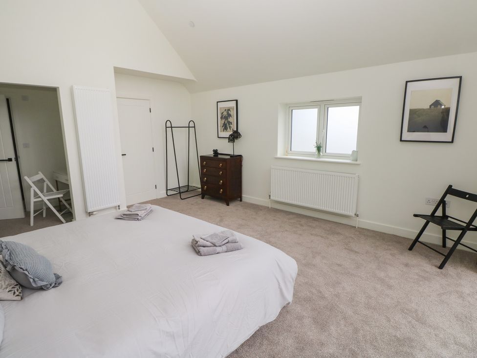 A bedroom with a bed and wardrobe at Ty Landsker in Milford Haven