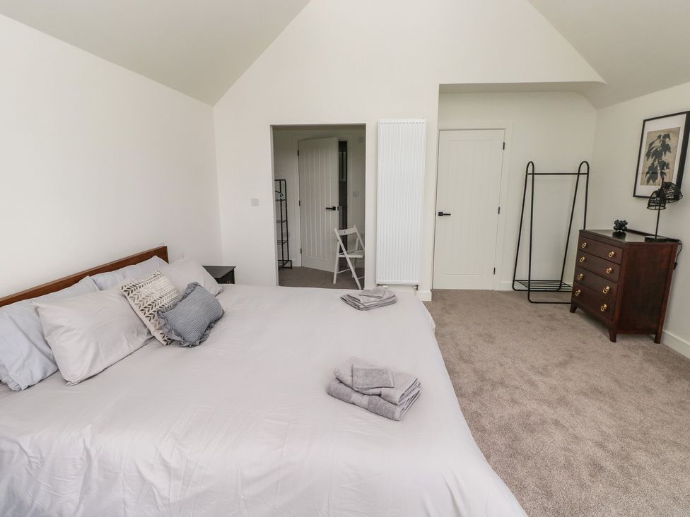 A bedroom with a bed and dresser at Ty Landsker in Milford Haven