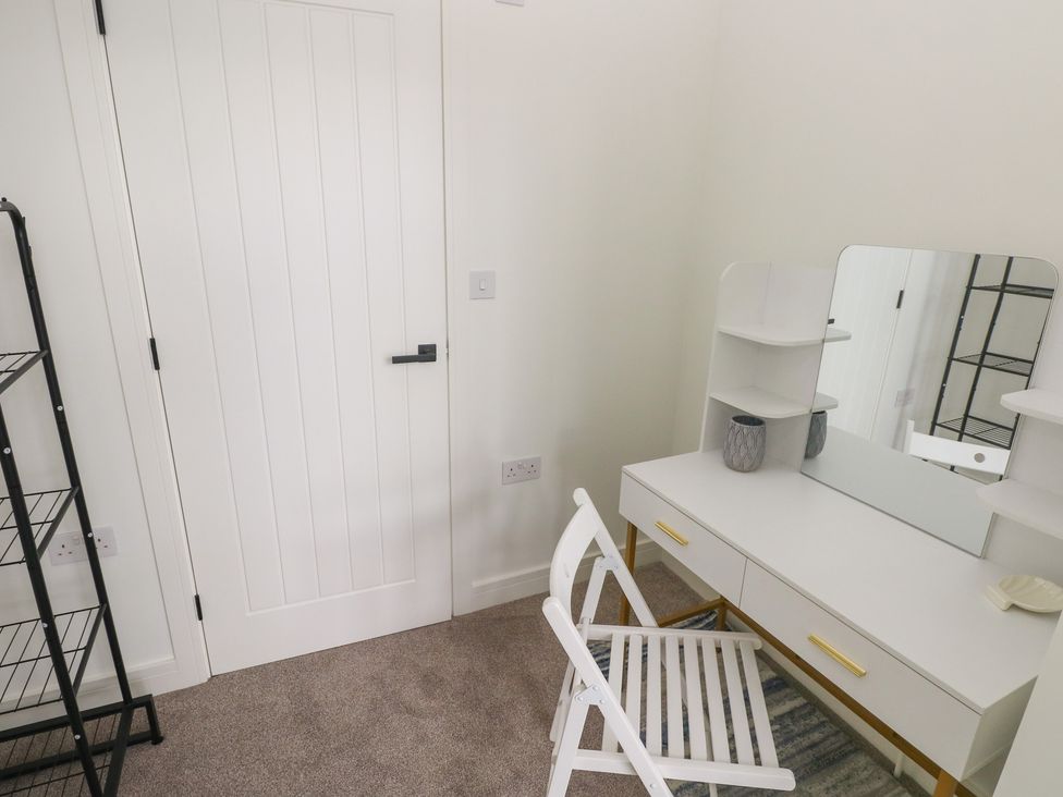A dressing room with a vanity desk and chair at Ty Landsker in Milford Haven