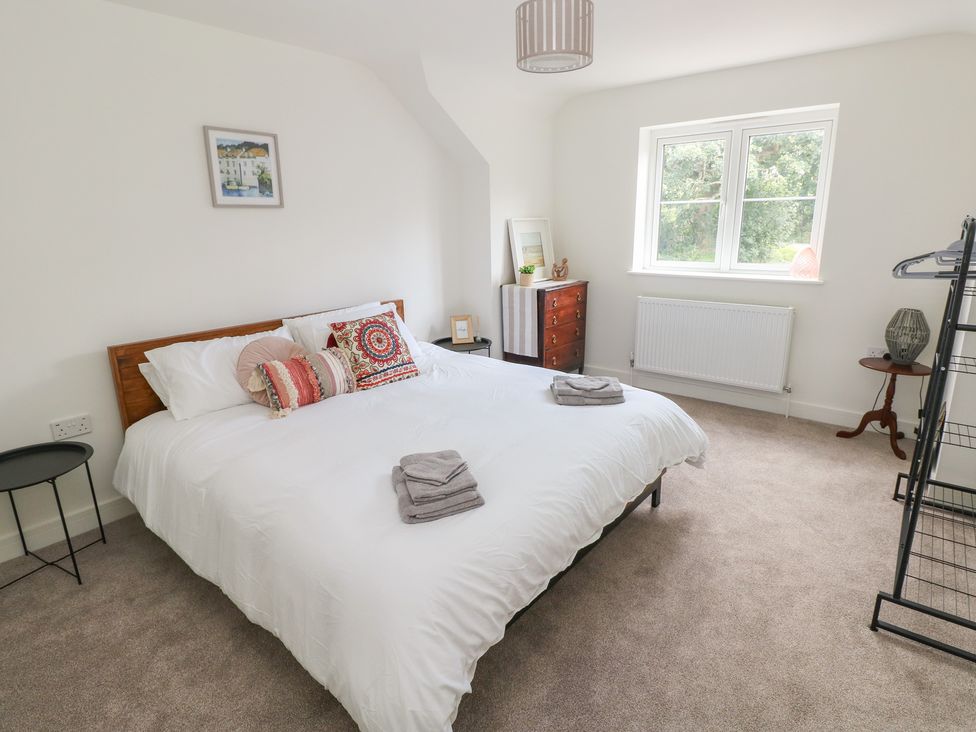 A bedroom with a bed and window at Ty Landsker in Milford Haven