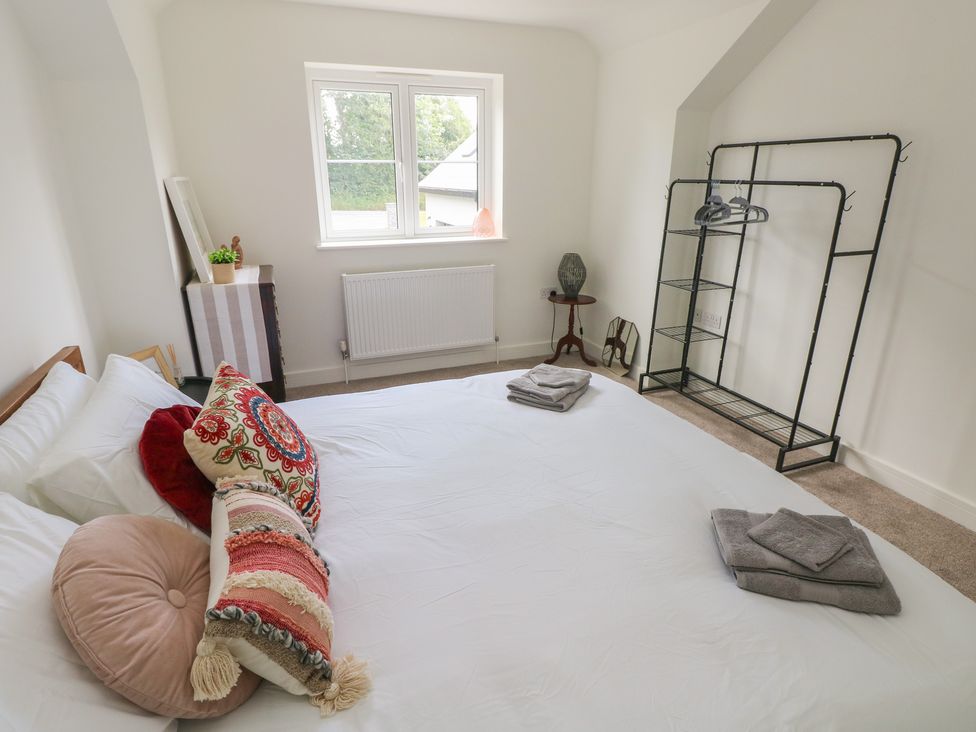 A bedroom with a bed and storage shelves at Ty Landsker in Milford Haven