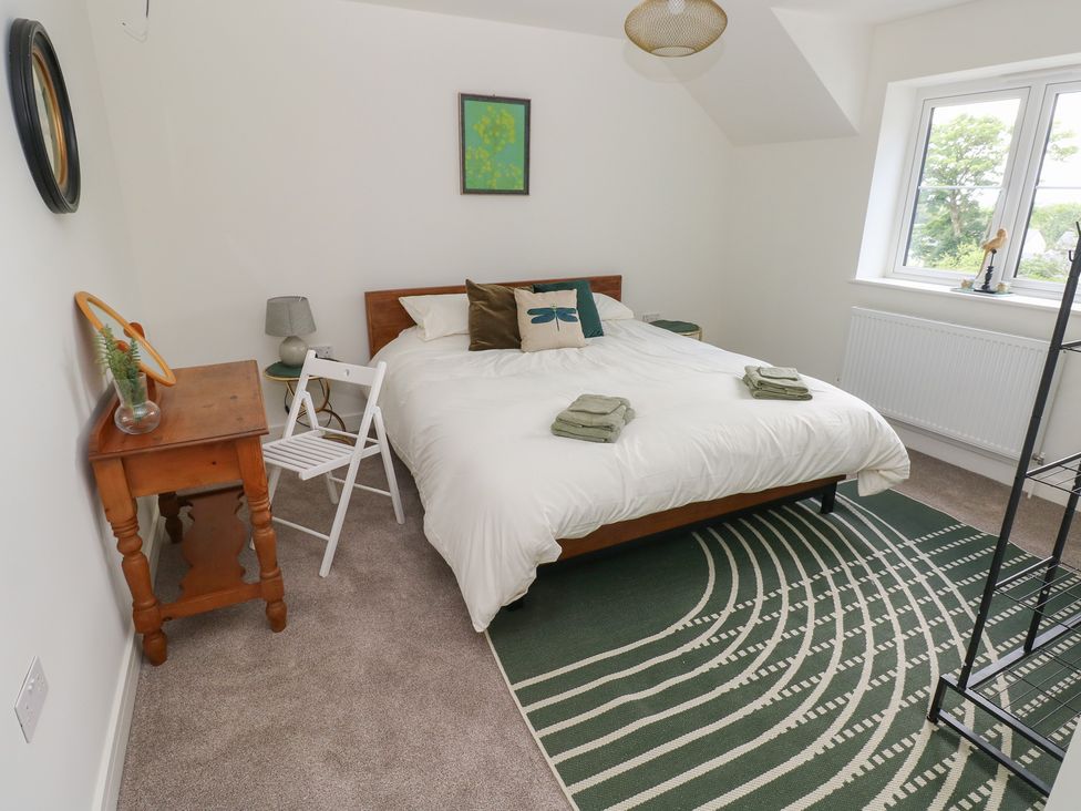 A bedroom with a bed and bedside table at Ty Landsker in Milford Haven