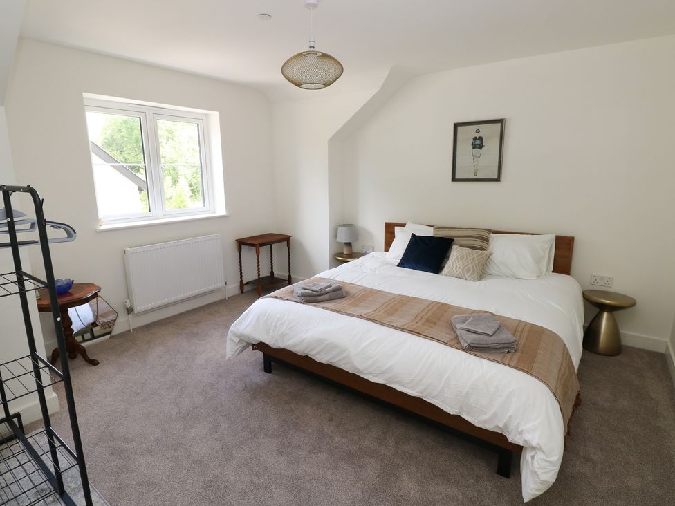 A bedroom with a bed and nightstand at Ty Landsker in Milford Haven