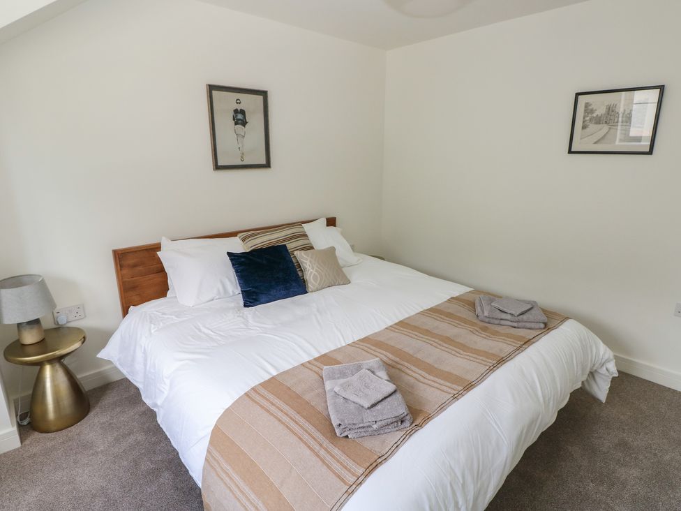 A bedroom with a bed and bedside table at Ty Landsker in Milford Haven