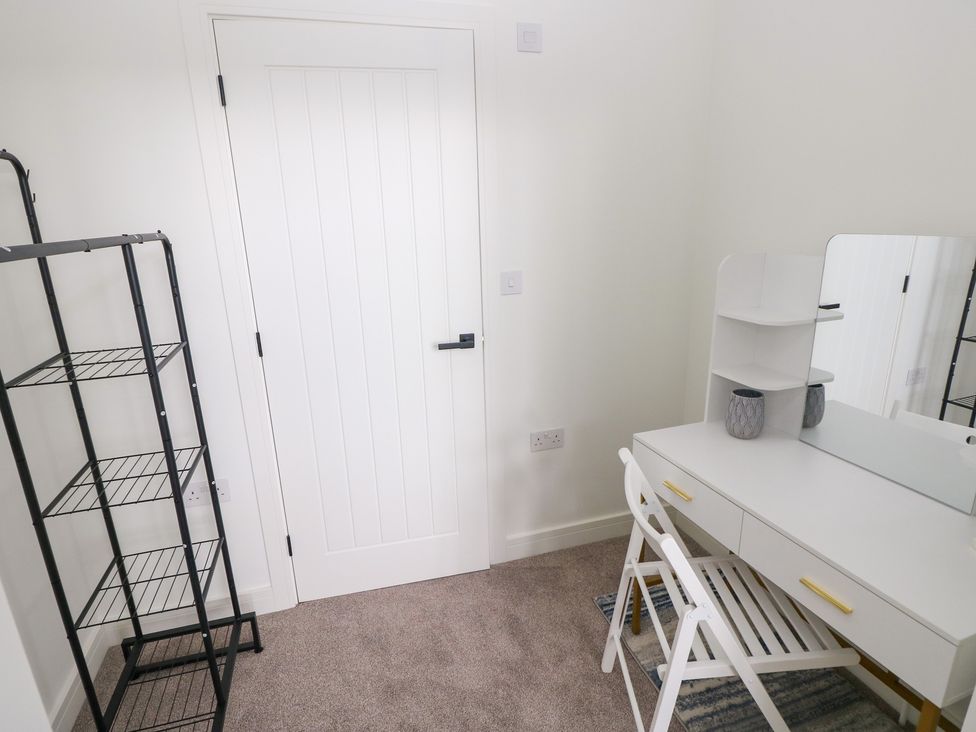 A bedroom with a desk and mirror at Ty Landsker Houghton near Neyland