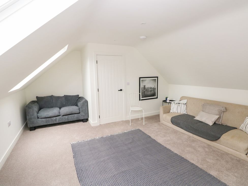 A living room with a sofa and chair at Ty Landsker in Houghton near Neyland