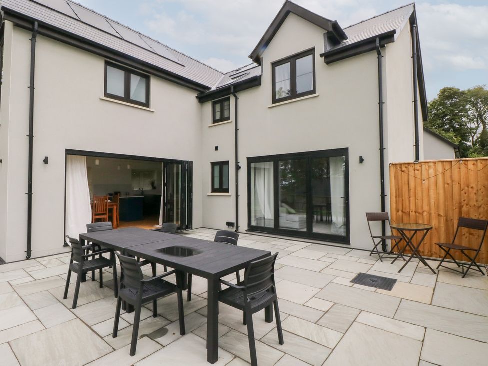 An outdoor dining area with a table and chairs at Ty Landsker in Houghton near Neyland