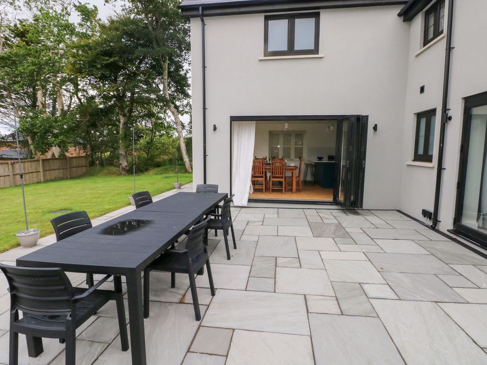 An outdoor patio area with a table and chairs at Ty Landsker in Houghton near Neyland