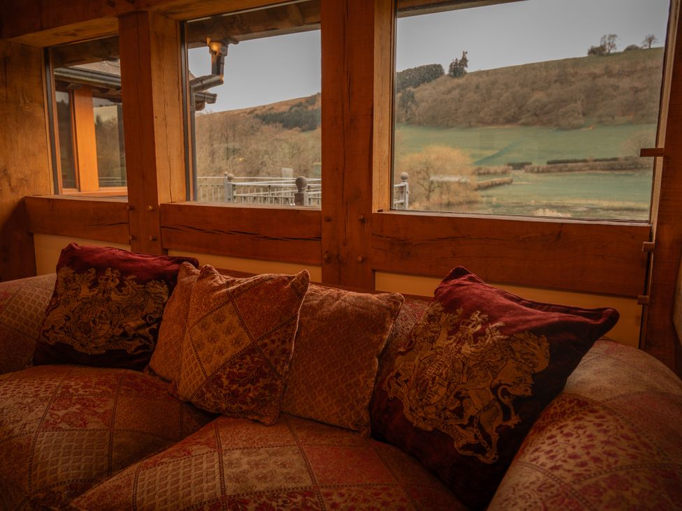 A sofa with cushions and a view of the hills at Stud Farm House in Bleddfa near Knighton