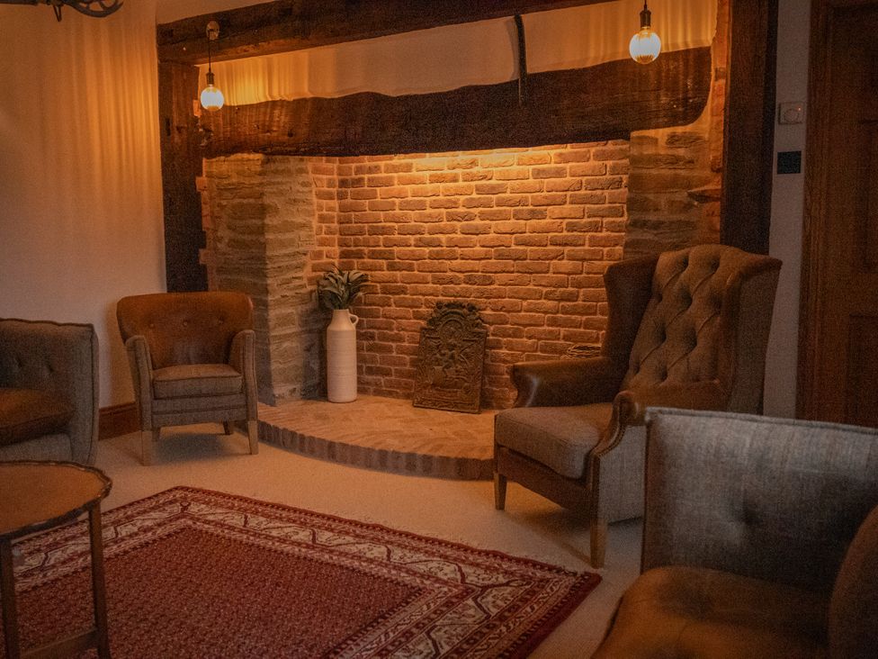 A living room with a fireplace and armchairs at Stud Farm House Bleddfa near Knighton
