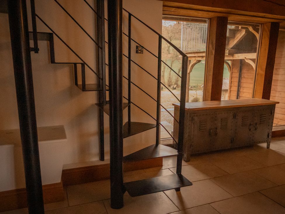 A spiral staircase and a wooden table in an indoor area at Stud Farm House Bleddfa near Knighton