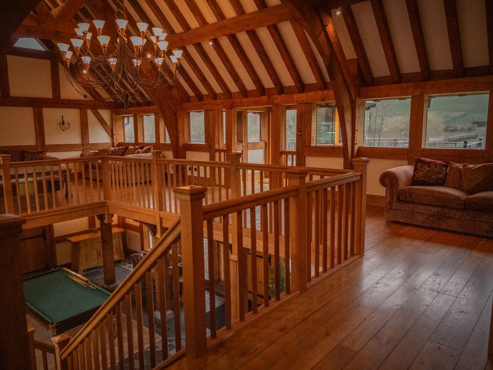 A living room with a chandelier and pool table at Stud Farm House Bleddfa near Knighton