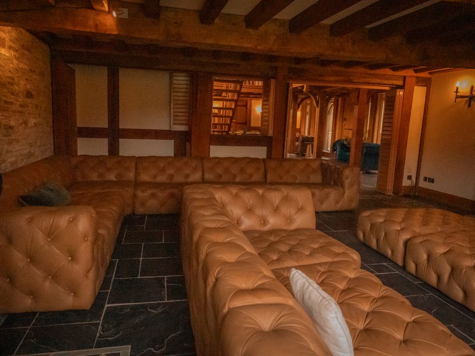 A snug with a large sofa and stone wall at Stud Farm House Bleddfa near Knighton