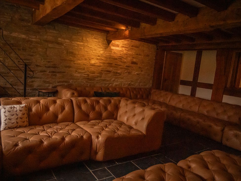 A snug with leather sofas and a staircase at Stud Farm House Bleddfa near Knighton