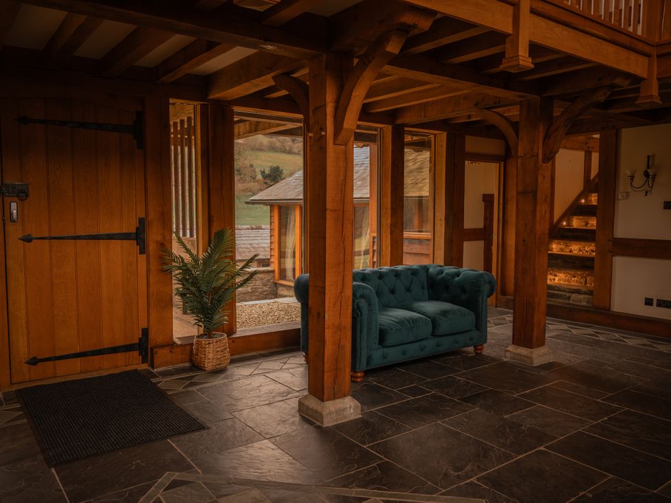 A hallway with a sofa and a door at Stud Farm House Bleddfa near Knighton