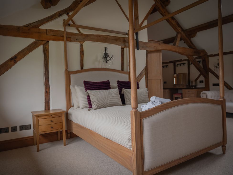 A bedroom with a four-poster bed and nightstand at Stud Farm House Bleddfa near Knighton