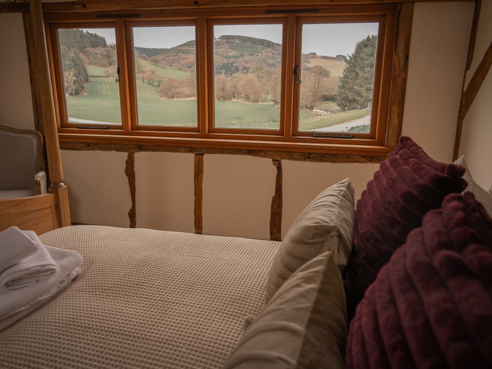 A bedroom with a bed and window view at Stud Farm House Bleddfa near Knighton