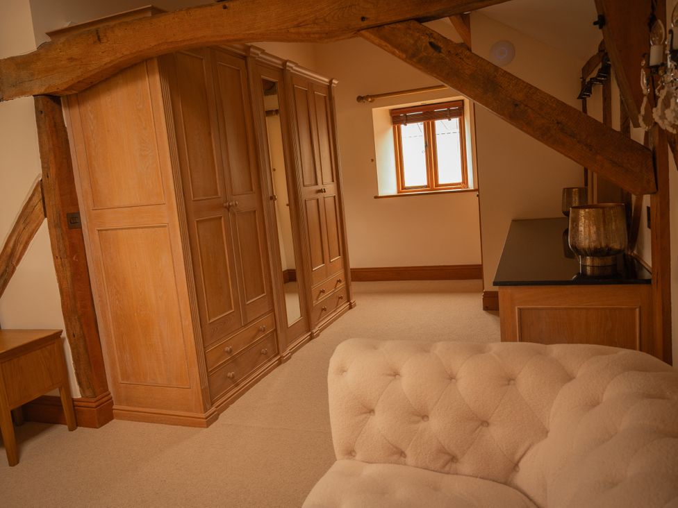 A bedroom with a wardrobe and table at Stud Farm House Bleddfa near Knighton